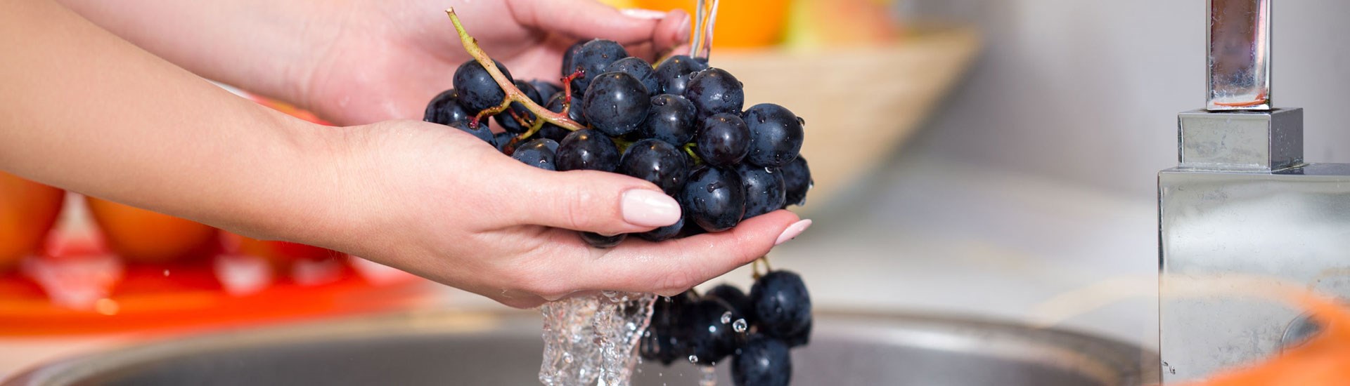 Integrity Water Solutions Woman Washing Grapes In Sink